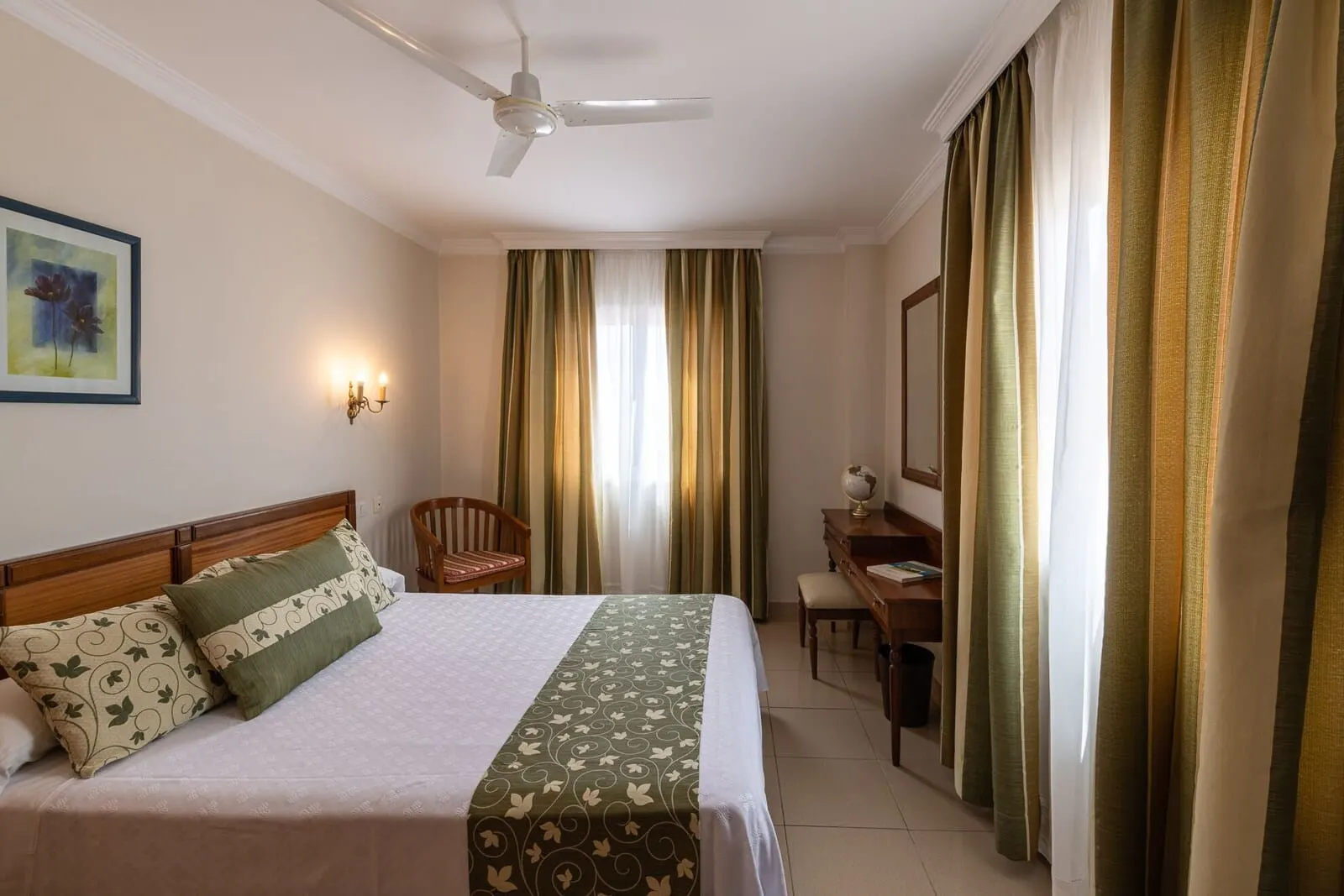 Hotel Marte: A hotel room with a bed, a chair, a desk, a globe, and curtains