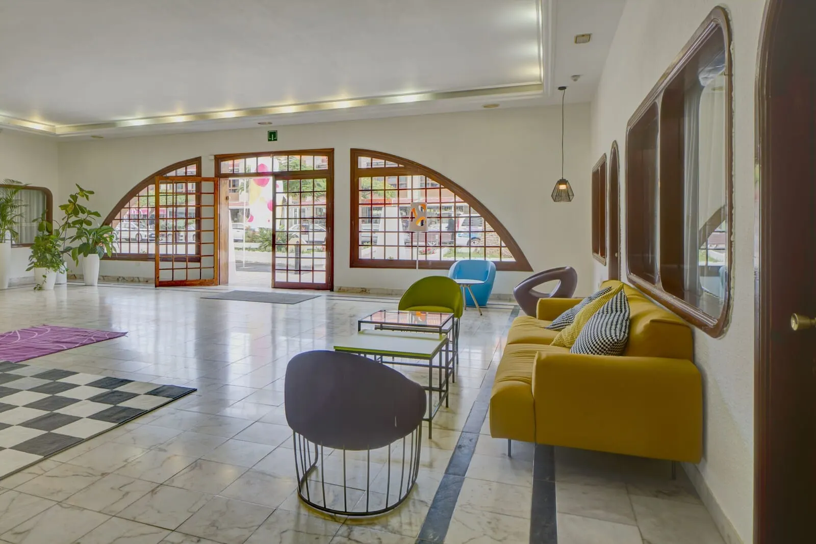 Coral Teide Mar: A spacious lobby with a checkered floor, a yellow sofa, a green chair, and a table