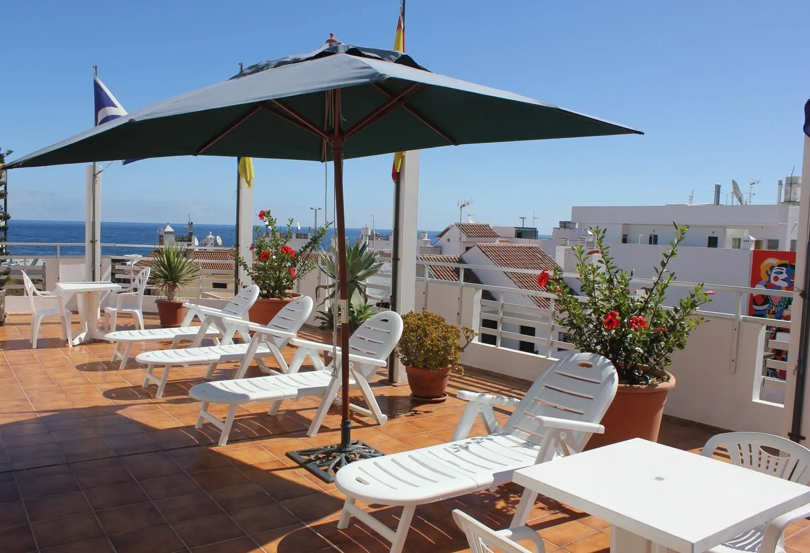 Hotel Sun Holidays: A terrace with white lounge chairs and a table, overlooking the sea