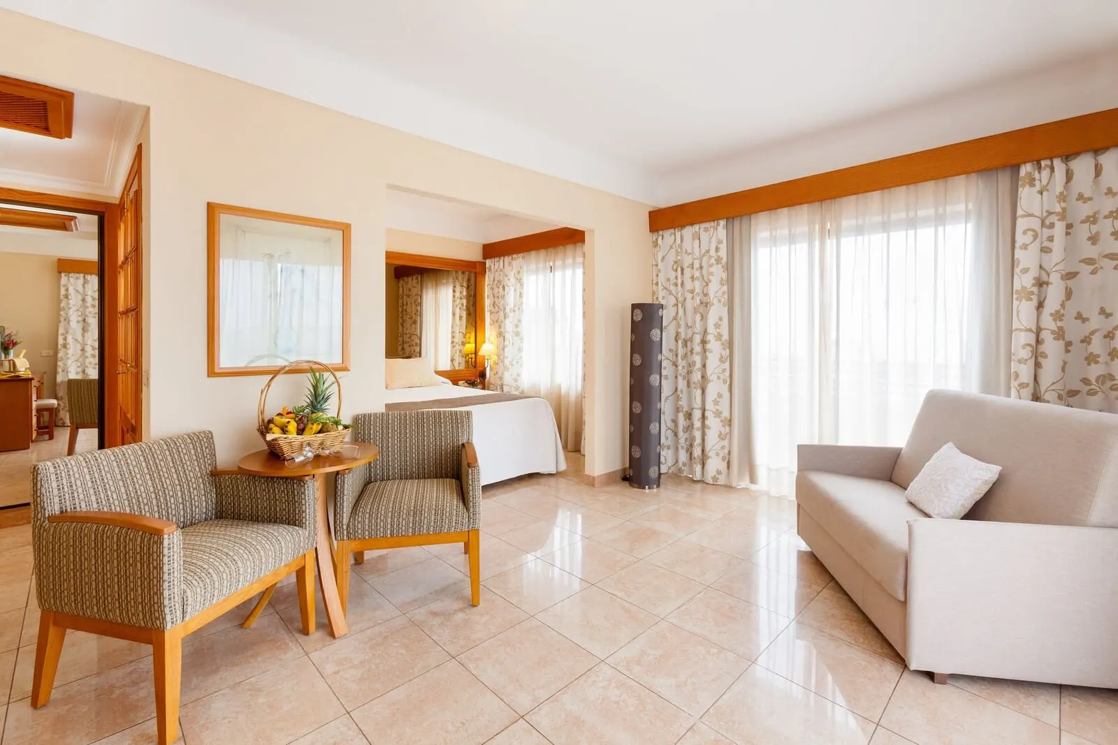 GF Fañabé: A hotel room with a bed, two armchairs, a sofa, a small table with a fruit basket