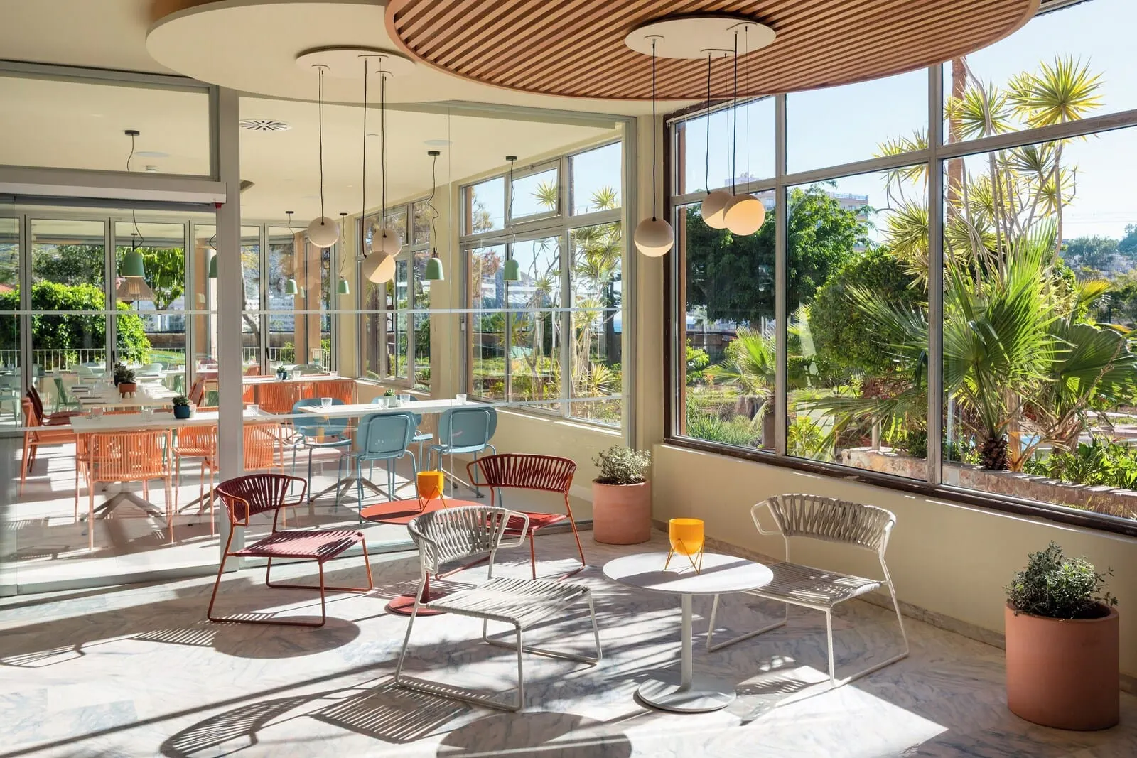Sol Arona Tenerife: A spacious indoor area with large windows, modern furniture, and potted plants