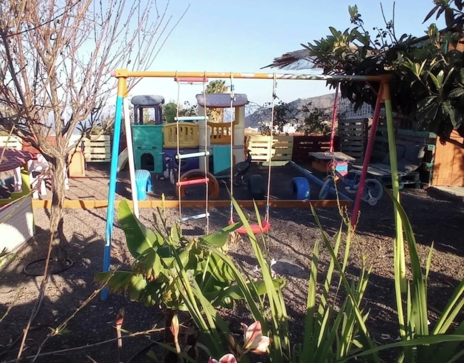 Hotel Rural La Raya 1866: A playground with a swing set, climbing structures, and a small pool