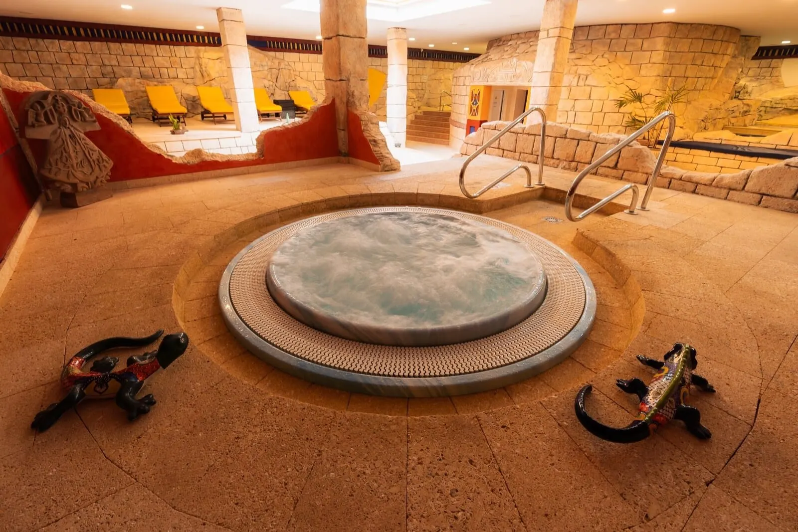 Europe Villa Cortés: A hot tub area with a stone wall backdrop, a seating area with yellow chairs