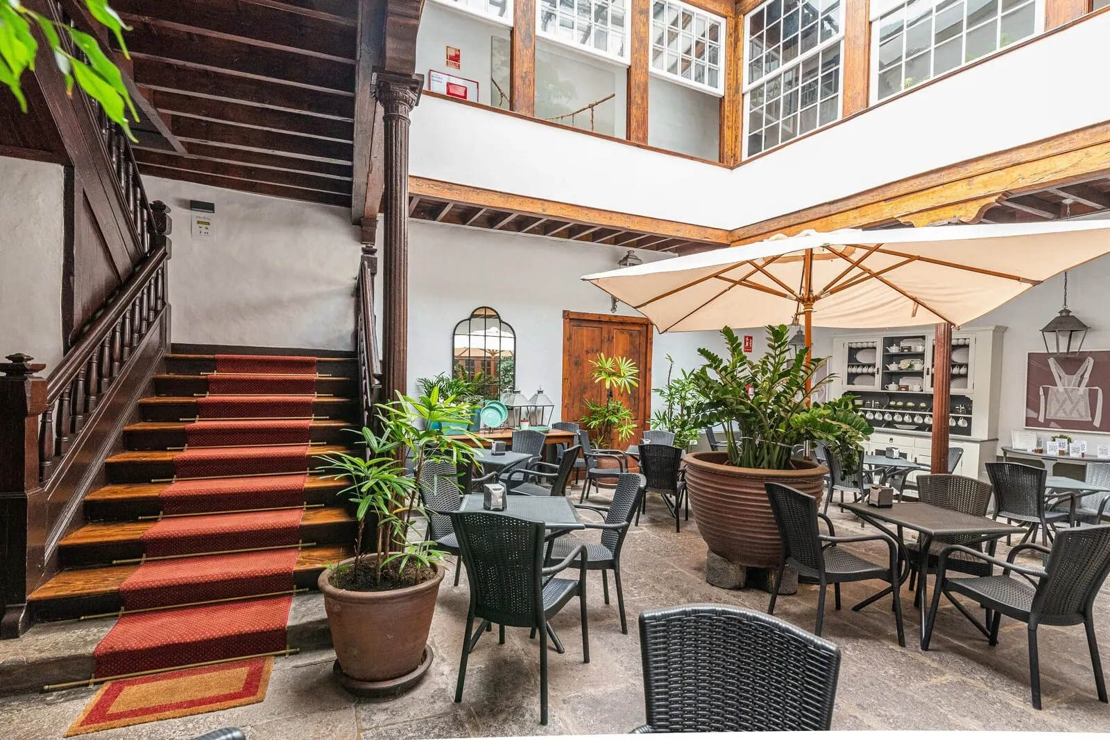 Isla Baja Suites: A multi-level indoor space with a staircase, seating area, and potted plants