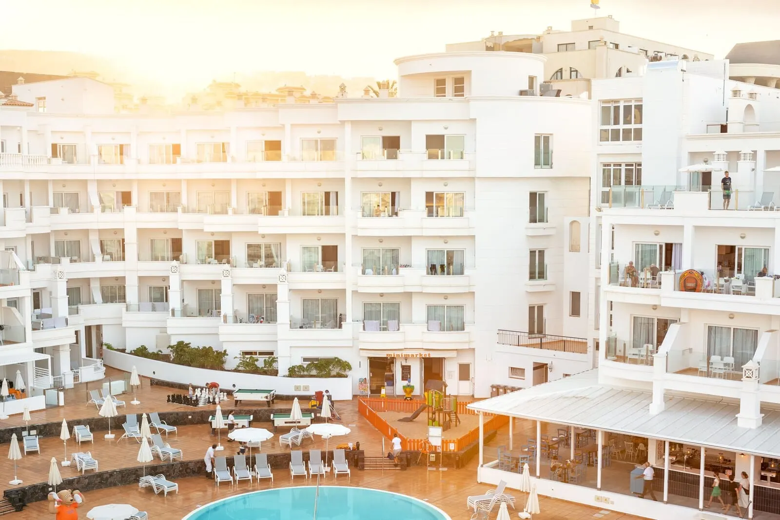 Sunwing Fañabé Beach: A multi-story hotel with a pool area, outdoor seating, and a bar/lounge area