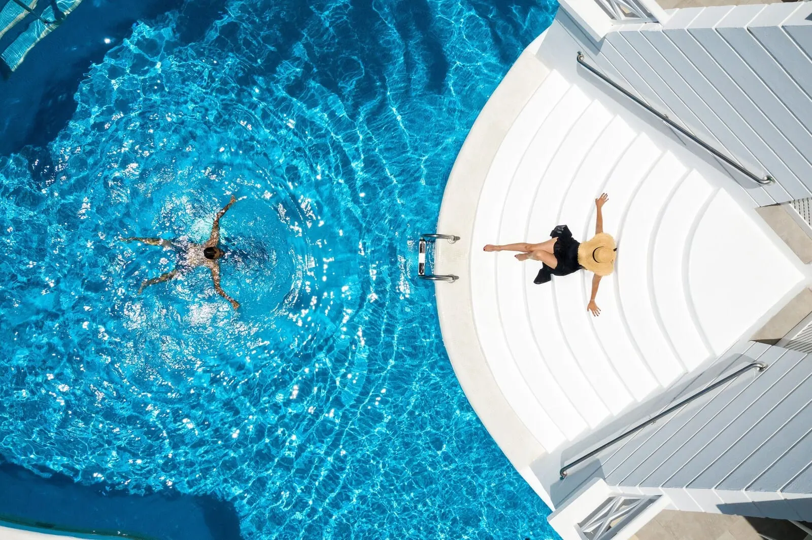 Lagos de Fañabé Beach Resort: A swimming pool with a person swimming and another person relaxing on the poolside