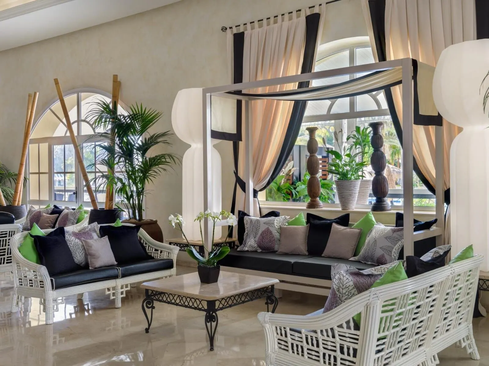 Gran Oasis Resort: A spacious lounge area with wicker furniture, a central coffee table, and potted plants