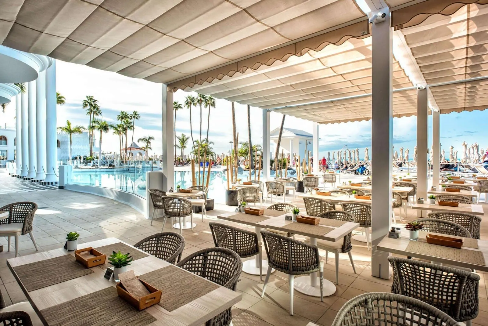 Guayarmina Princess: A spacious outdoor dining area with wicker furniture, a pool
