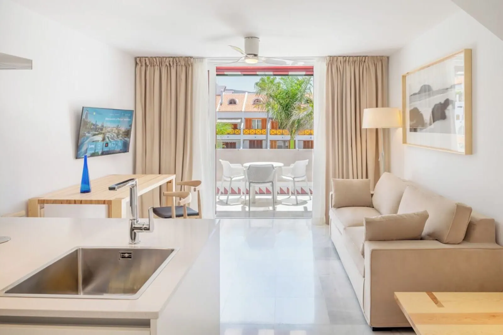 Parque Santiago IV: A modern hotel room with a kitchenette, a dining area, a sofa