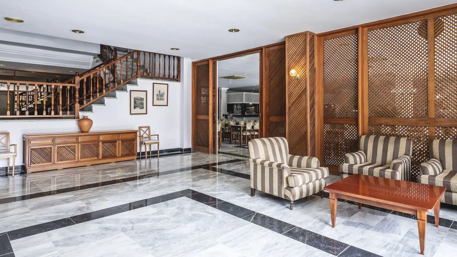 Be Smart Florida Plaza: A spacious lobby with a marble floor, a wooden staircase, and striped armchairs