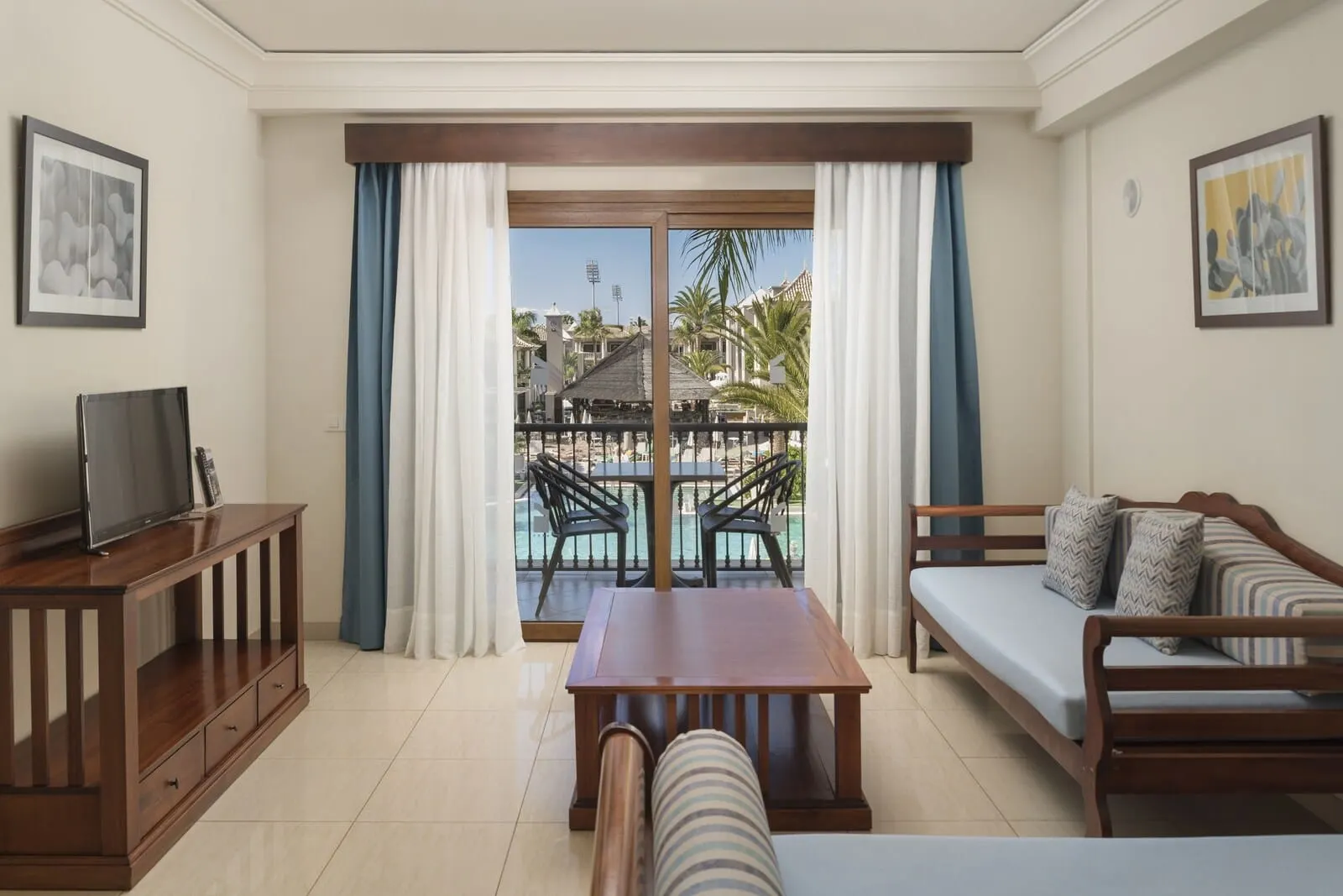 Marylanza Suites & Spa: A hotel room with a balcony, a sofa, a TV stand, and a dining table