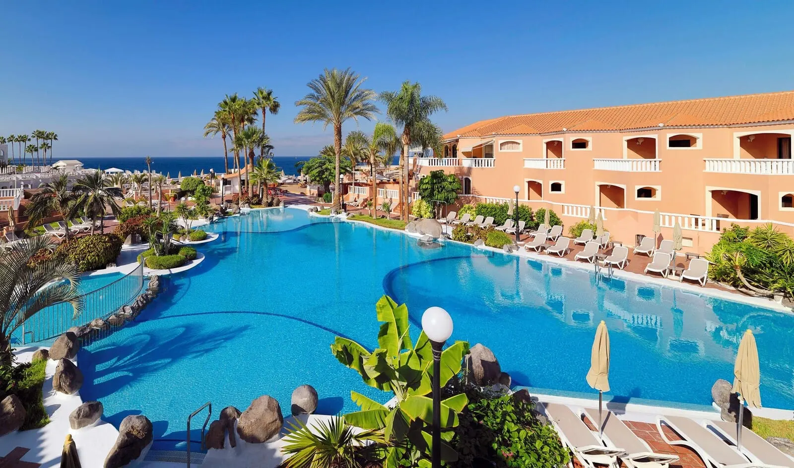 Sol Sun Beach Apartamentos: A resort pool with lounge chairs and palm trees