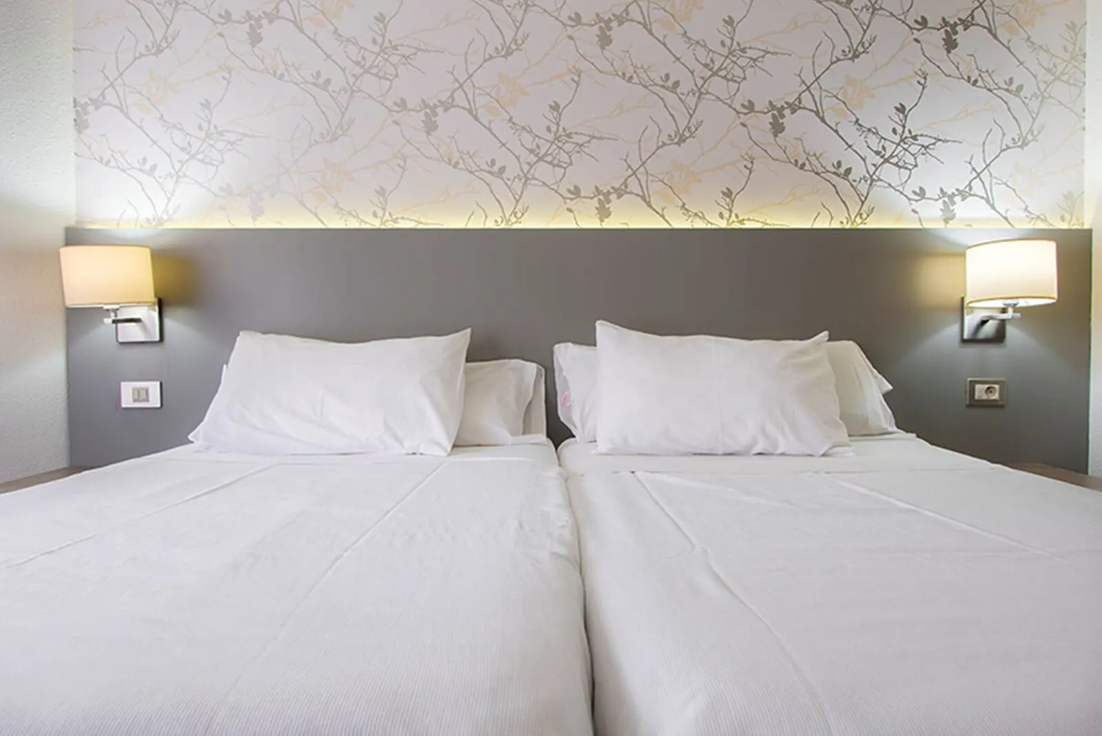 HG Tenerife Sur: A double bed with white linens and two wall-mounted lamps on either side