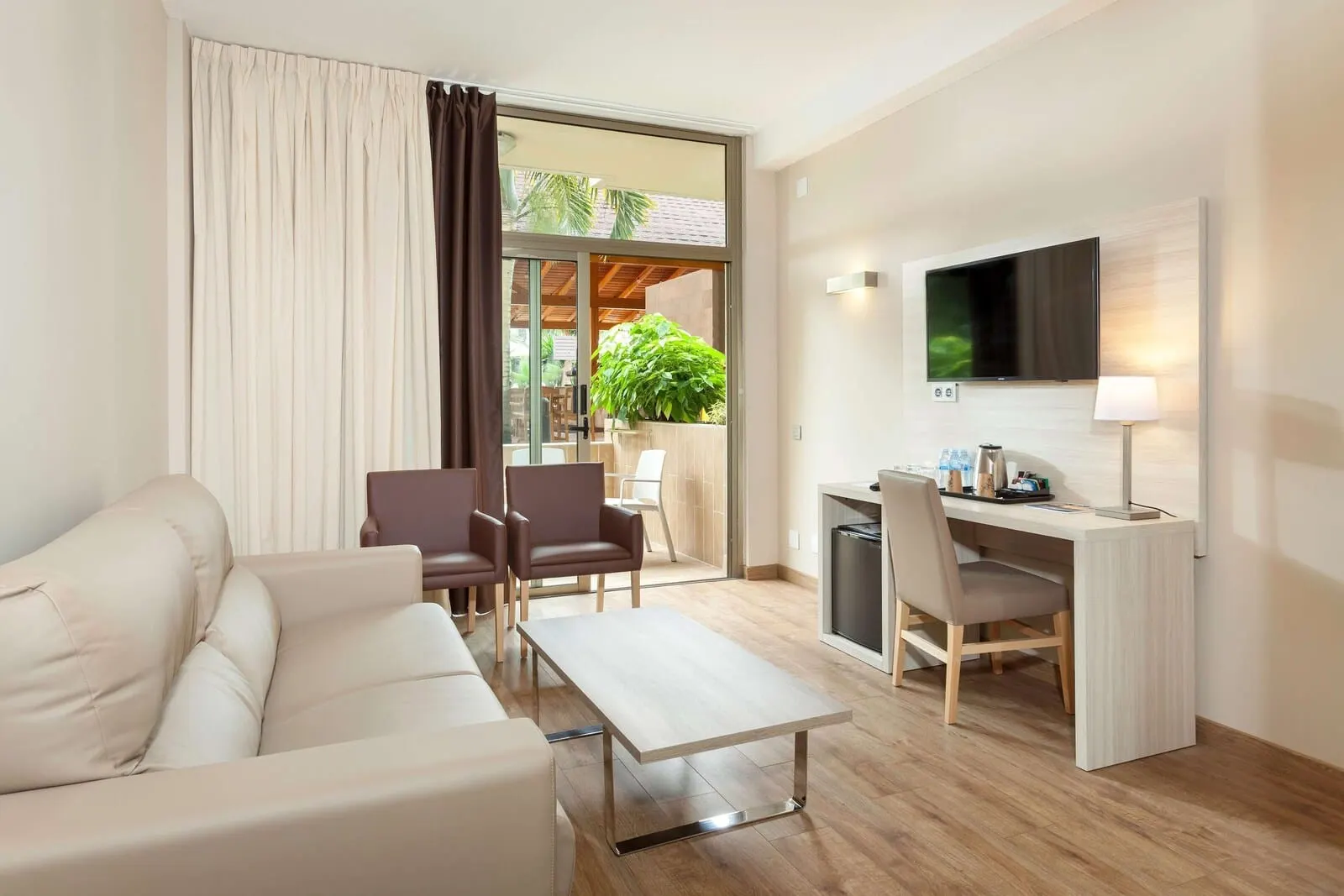 Best Tenerife: A modern living room with a sofa, a coffee table, a desk, and a TV