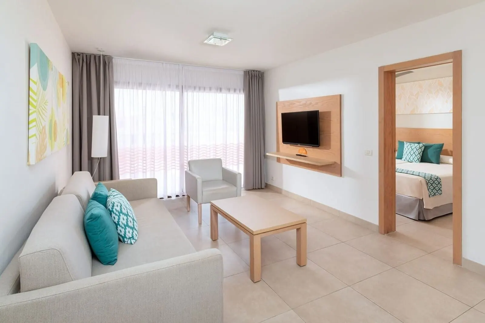 Tagoro Family & Fun Costa Adeje: A modern living room with a sofa, a coffee table, a TV mounted on the wall