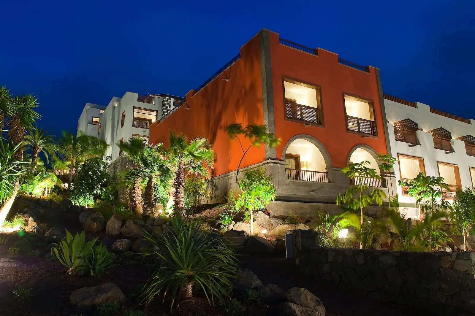 Hacienda del Conde Meliá Collection Golf & Spa: A multi-story hotel with a red facade, multiple balconies