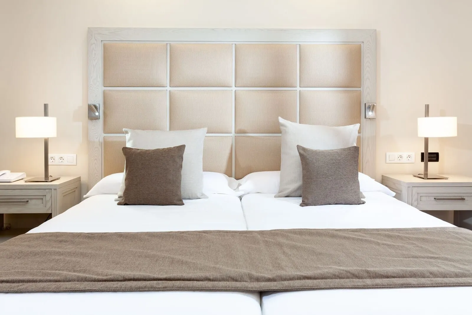 Hotel Riu Garoé: A neatly made bed with a headboard, two bedside tables with lamps