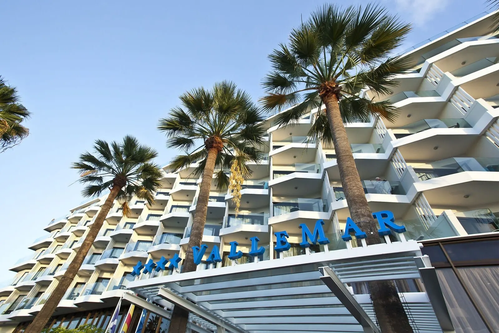 Hotel Vallemar: A multi-story hotel with balconies and palm trees