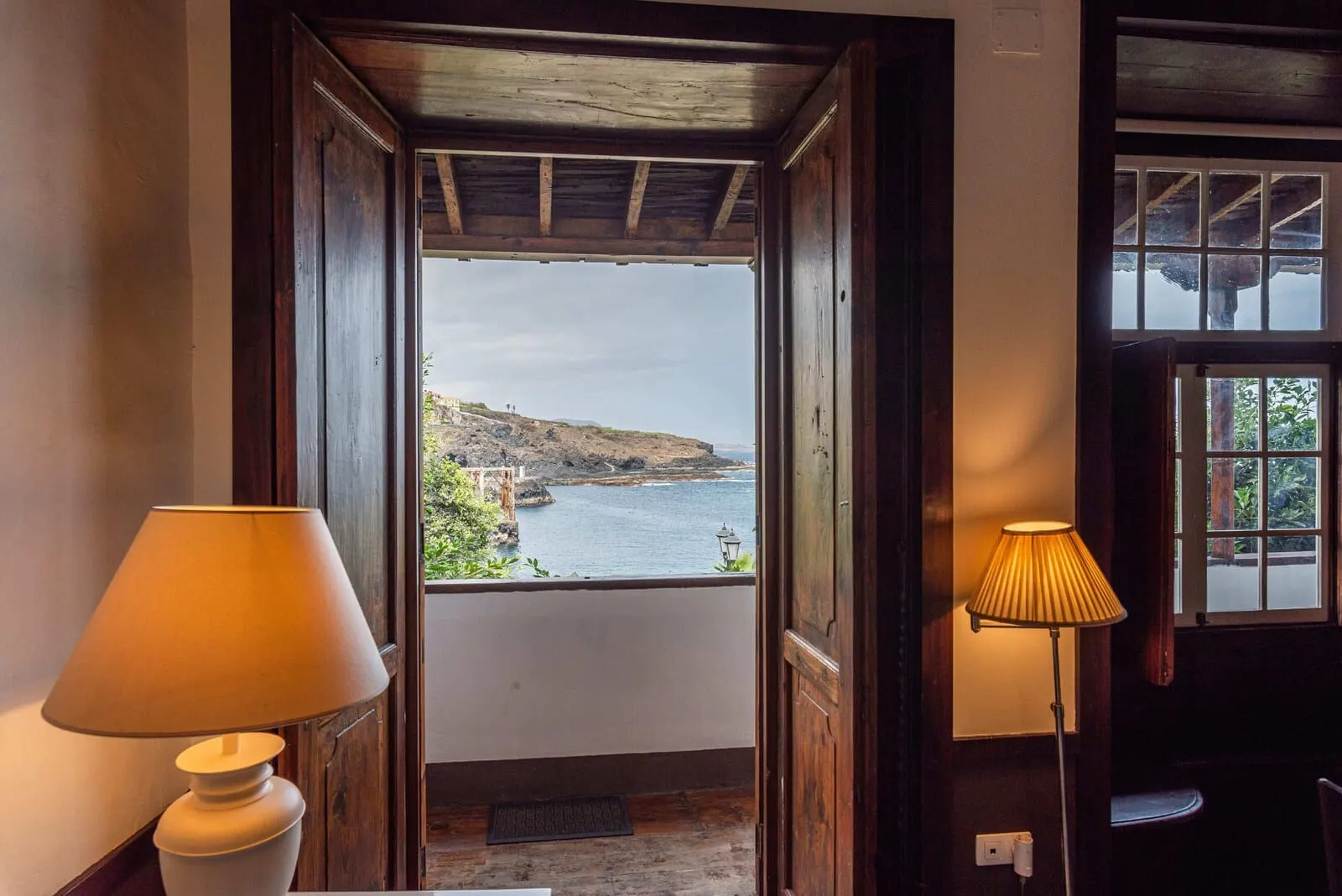 Isla Baja Suites: A wooden door leading to a balcony with a view of a coastal landscape