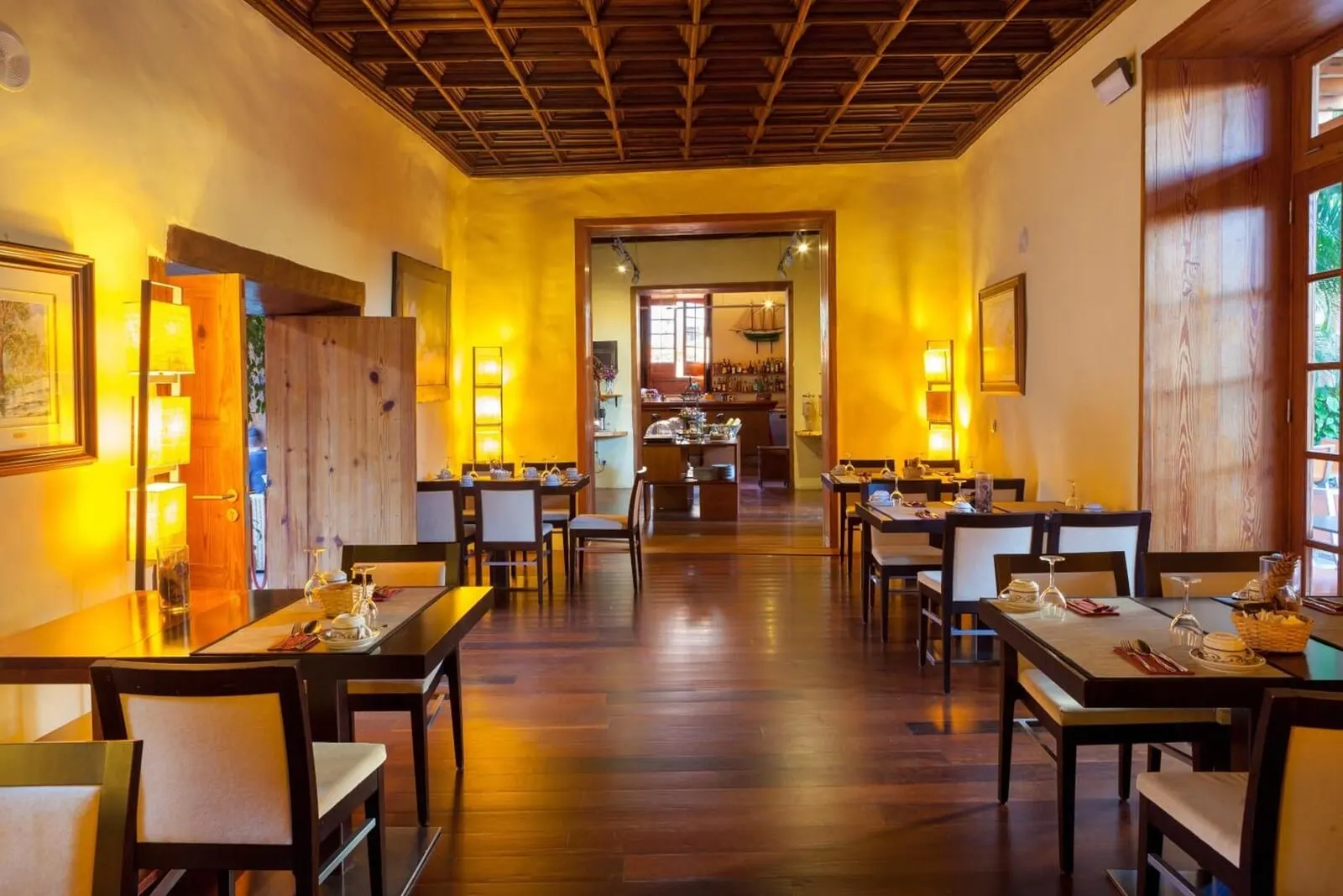 Hotel La Quinta Roja: A restaurant with wooden tables and chairs, a central bar area, and a warm