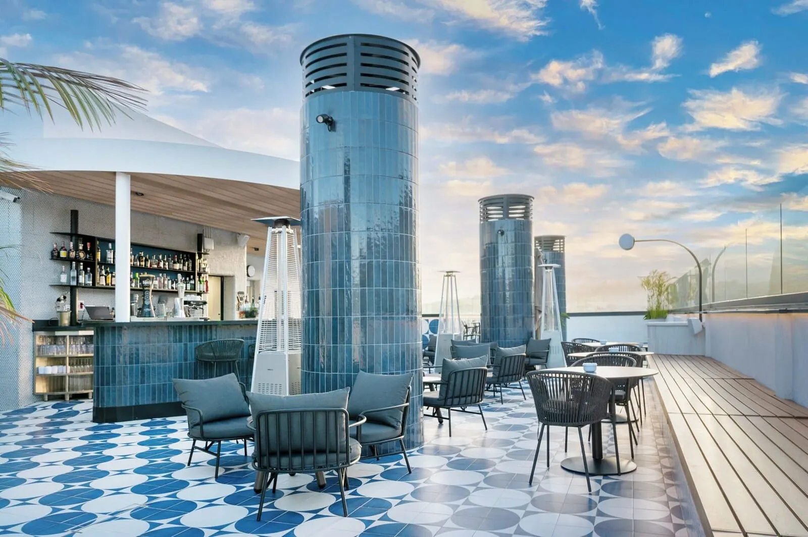 Barceló Santa Cruz Contemporáneo: A rooftop bar with a blue and white tiled floor, modern seating