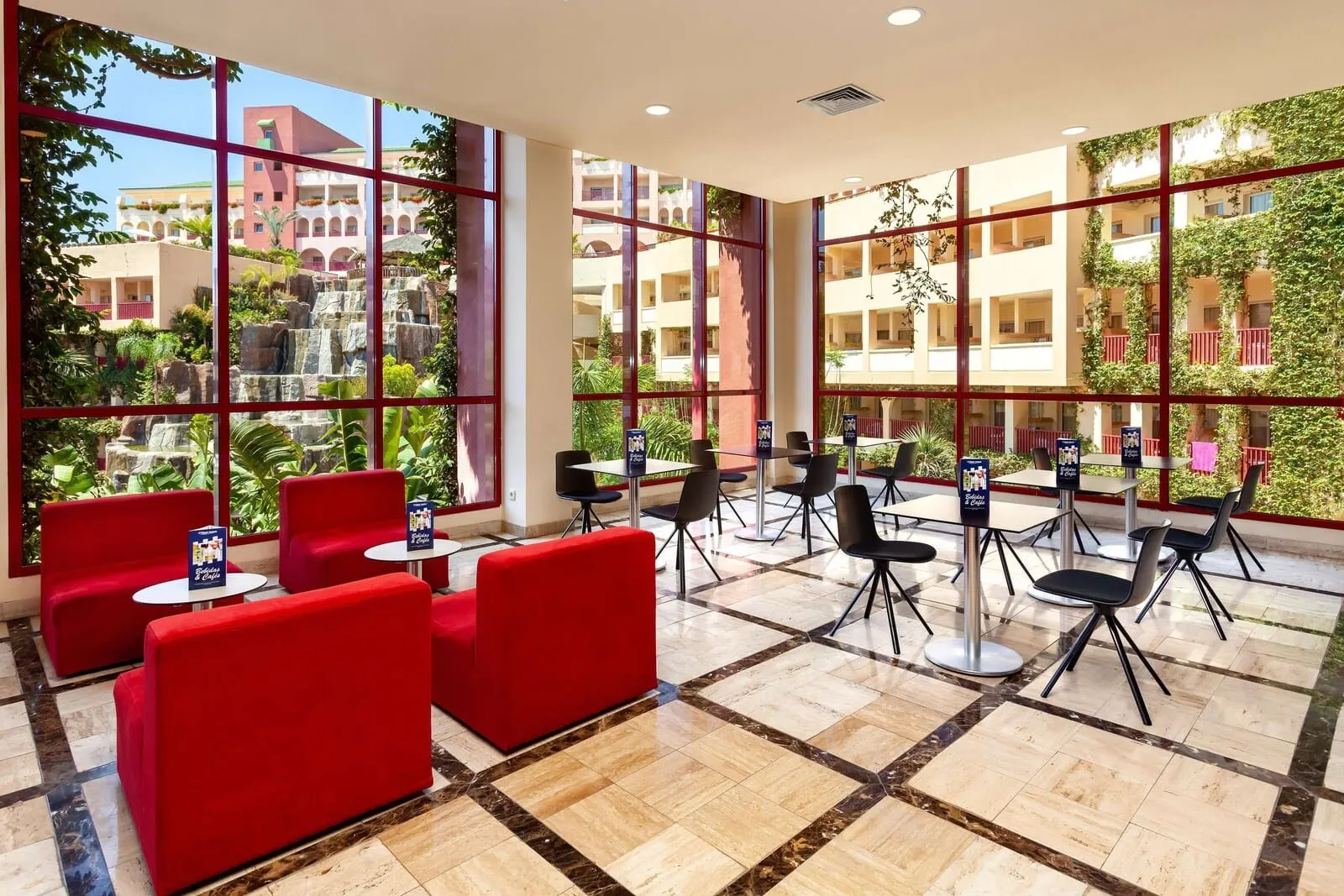 Best Jacaranda: A hotel lobby with red seating, a tiled floor