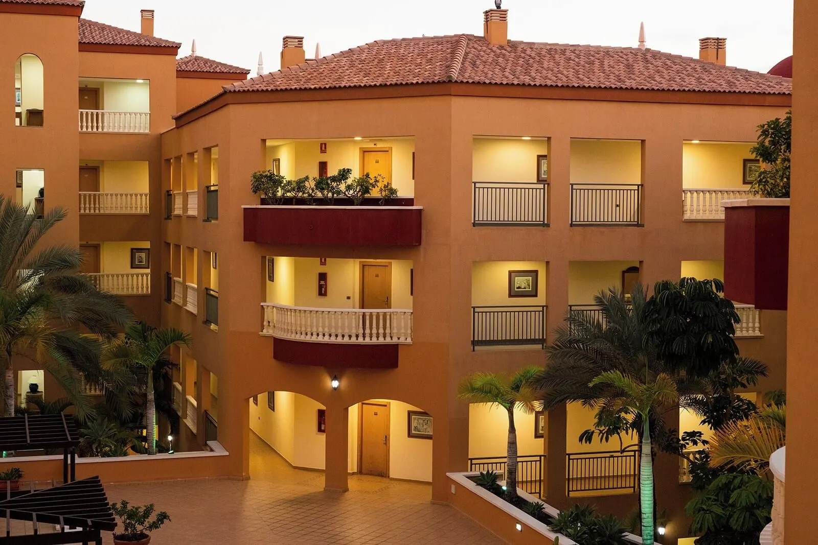Grand Muthu Golf Plaza Hotel & Spa: A multi-story hotel with balconies, a central courtyard, and outdoor plants