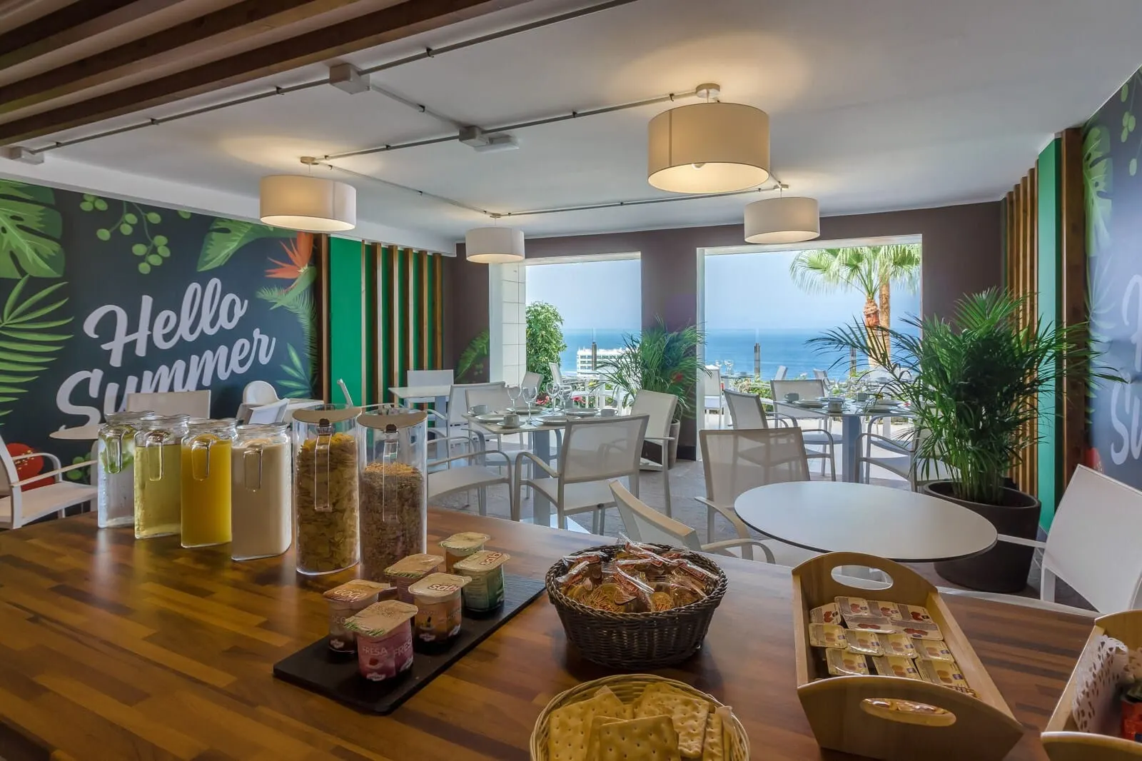 Klayman Diamond Aparthotel: A restaurant with a view of the ocean, featuring a 'Hello Summer' mural