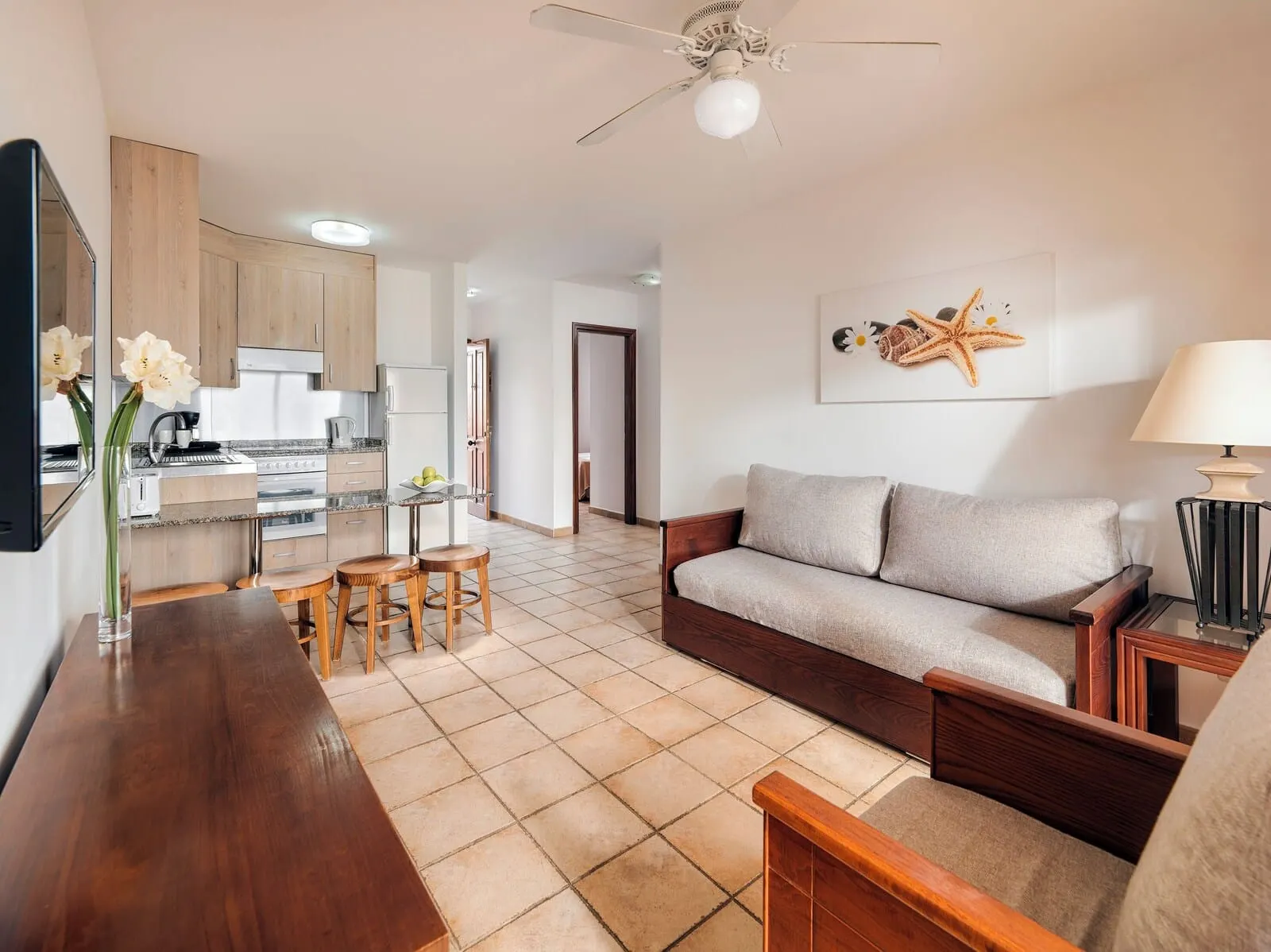 Sol Sun Beach Apartamentos: A modern living room with a sofa, a wooden coffee table, and a TV