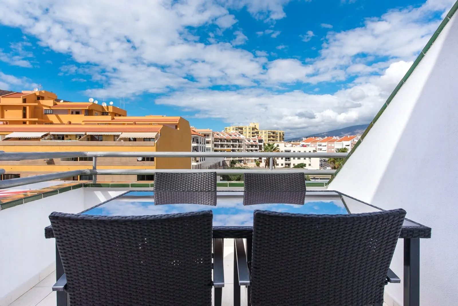 Andrea's Hotel Tenerife: A balcony with a glass table and two wicker chairs