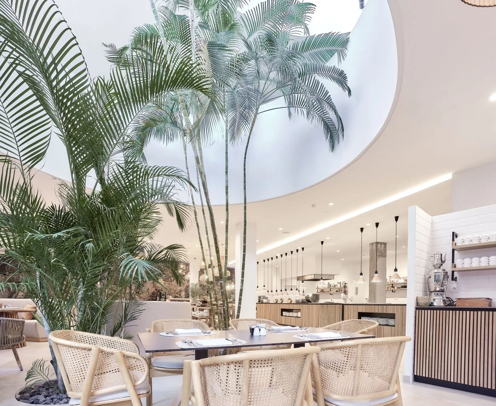 Domes Baobab Suites: A modern dining area with a high ceiling and natural light