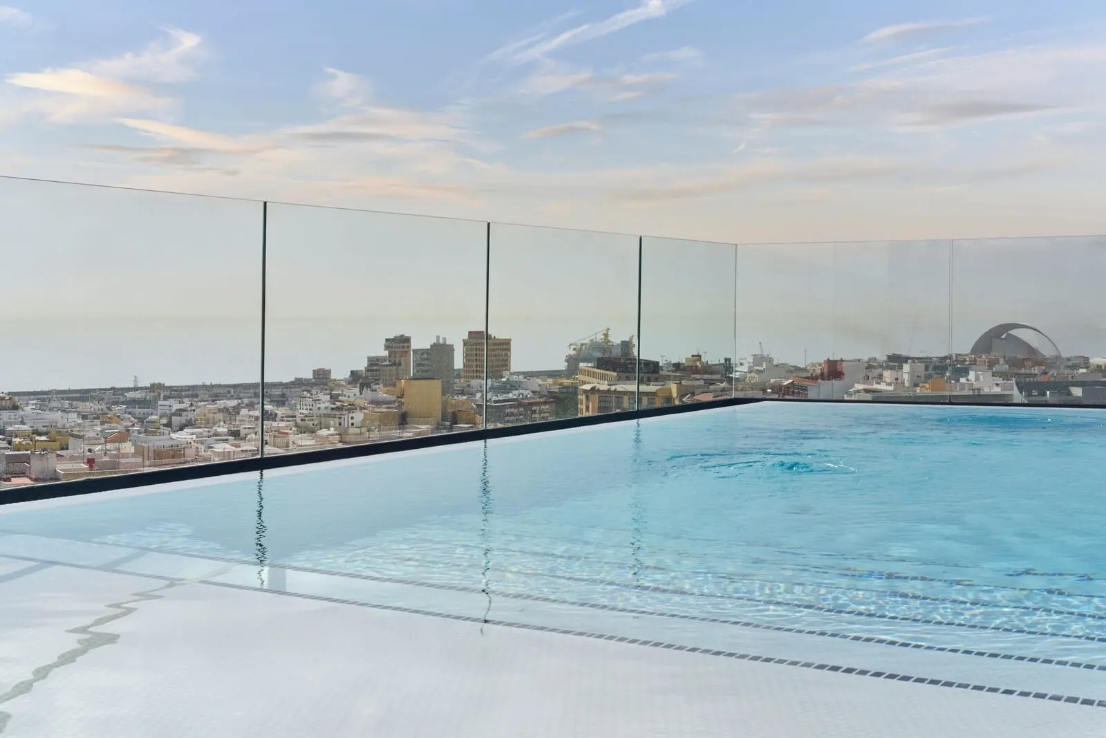 Barceló Santa Cruz Contemporáneo: A rooftop infinity pool with a cityscape view, including a distinctive arch structure