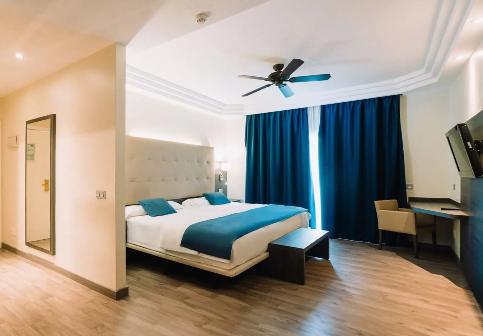 Park Club Europe: A modern hotel room with a large bed, a desk, and a ceiling fan