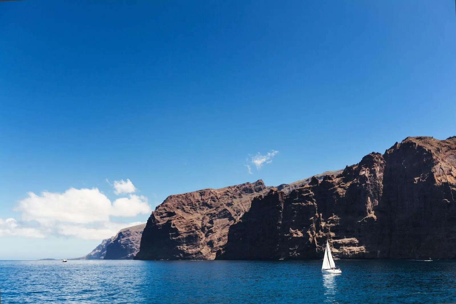 Hotel Rural Finca Salamanca: A sailboat on a calm sea with rocky cliffs in the background