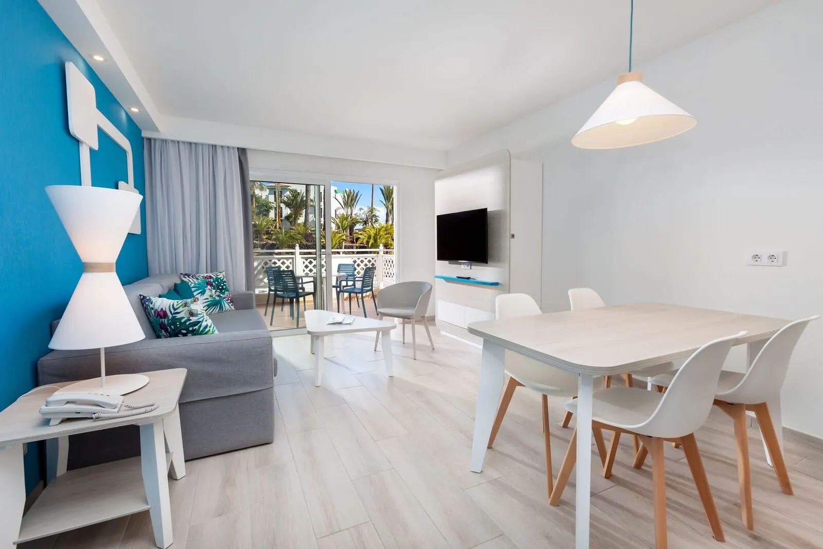 Hotel Tropical Park: A modern living room with a grey sofa, a white coffee table