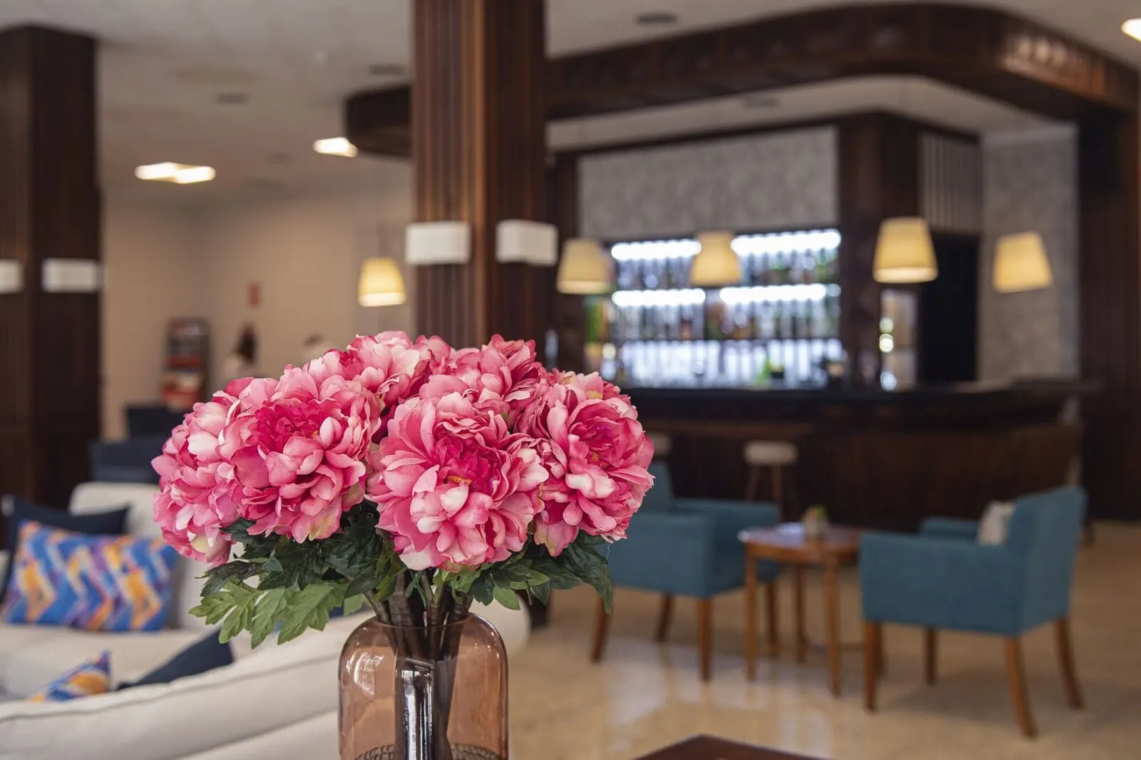 Hotel Marte: A lobby area with a bar, seating, and a vase of flowers