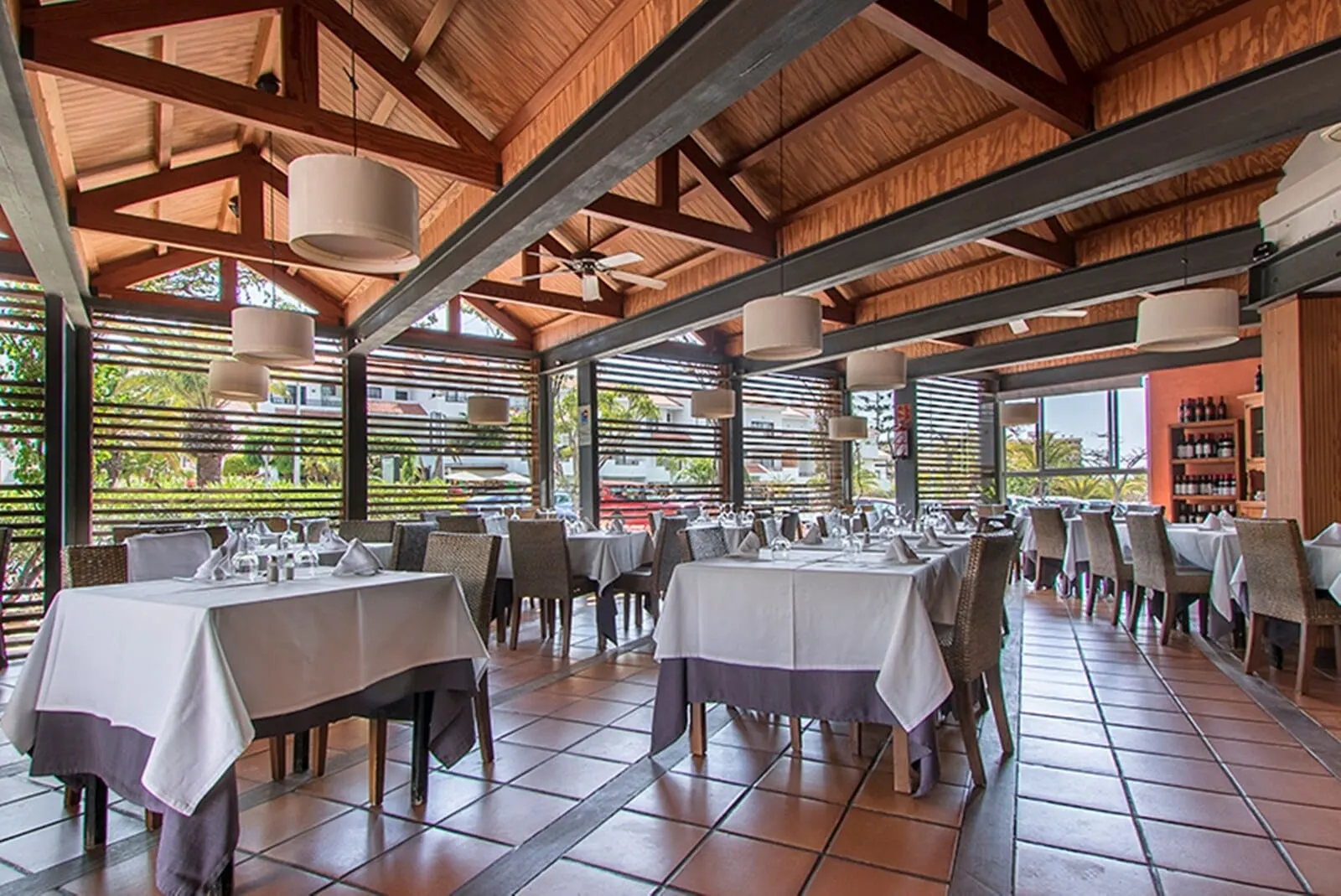HG Tenerife Sur: A spacious outdoor dining area with multiple tables and chairs, large hanging lights