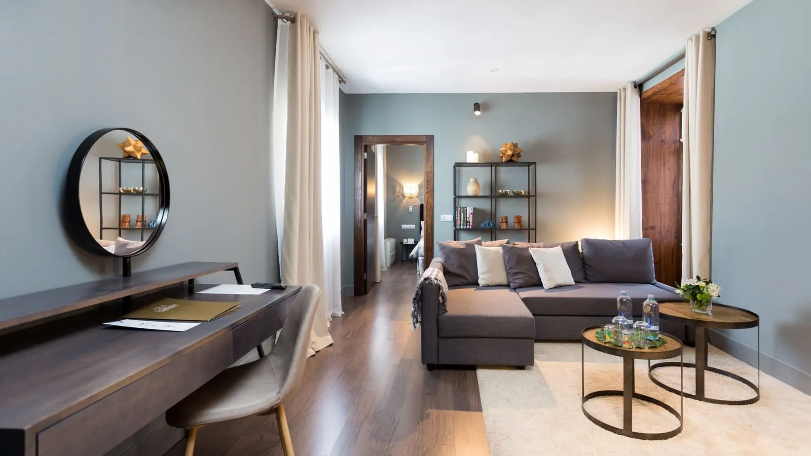 La Laguna Gran Hotel: A modern living room with a sofa, a coffee table, a desk, and a bookshelf