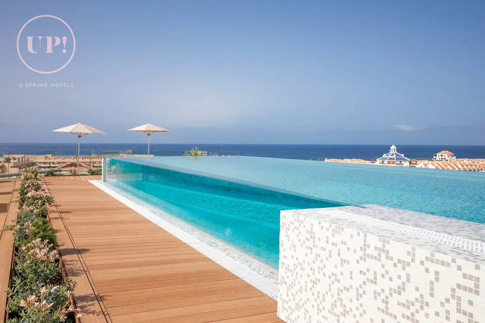 Spring Hotel Vulcano: A long, clear infinity pool with a wooden deck and flower beds