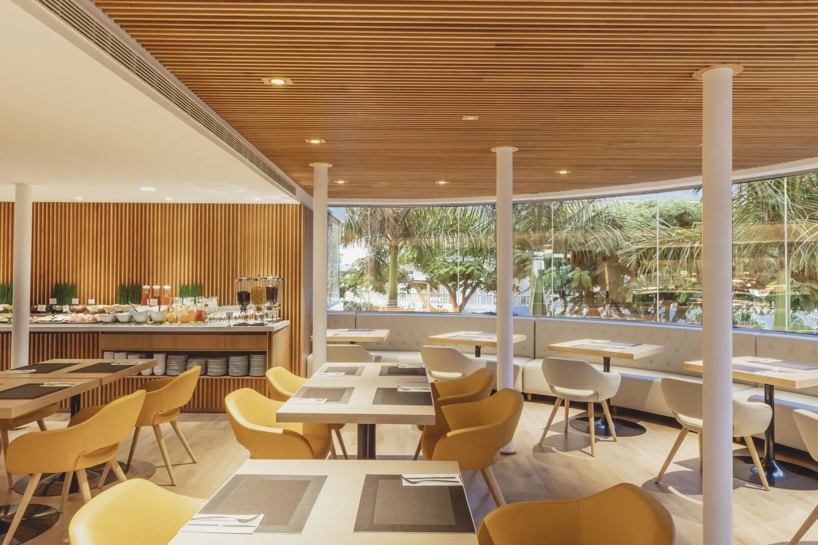 Flamingo Beach Mate: A modern restaurant with wooden ceiling panels, yellow chairs