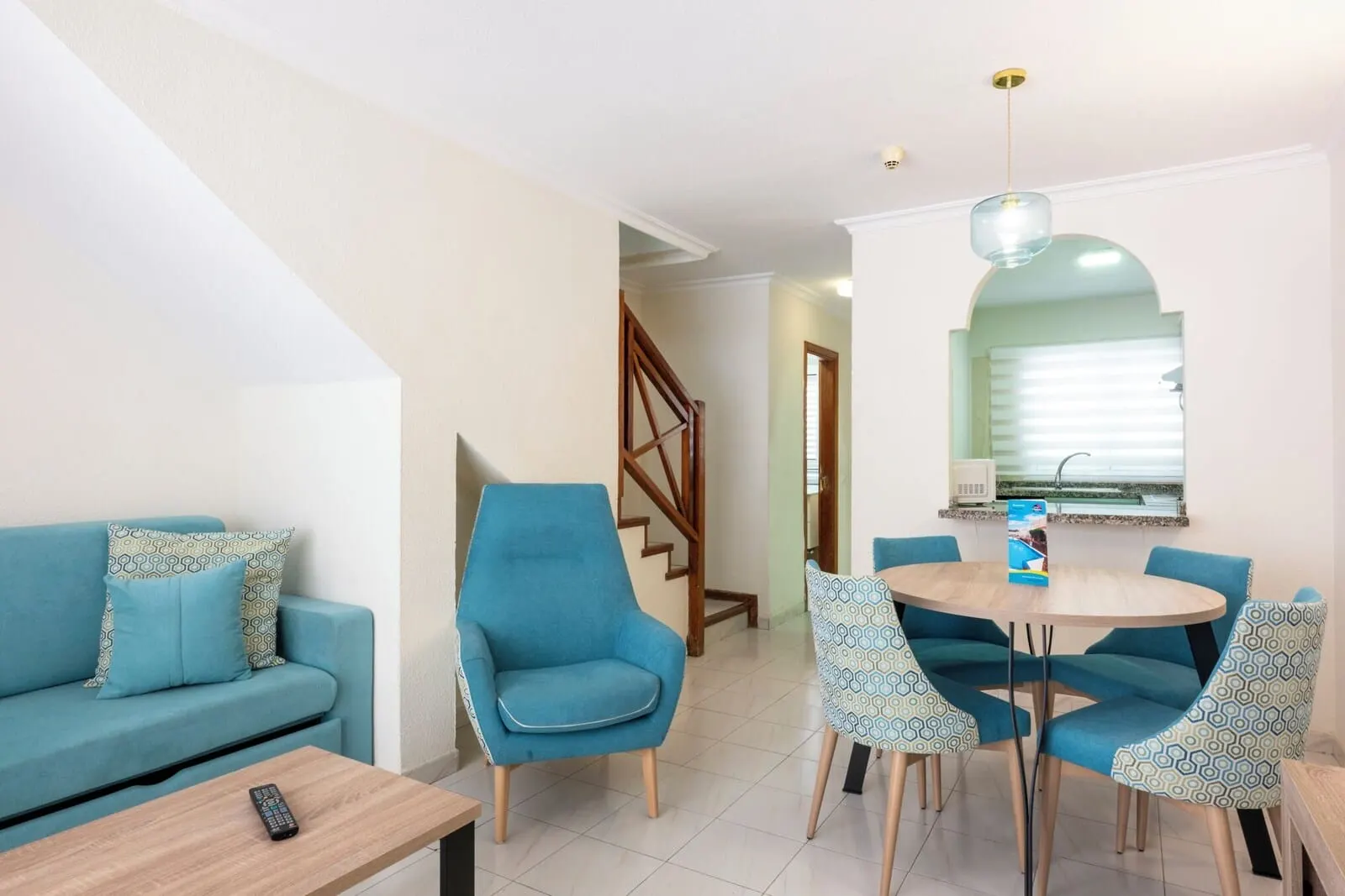 Ona Los Claveles: A living room with a sofa, a coffee table, and a dining area with chairs and a table