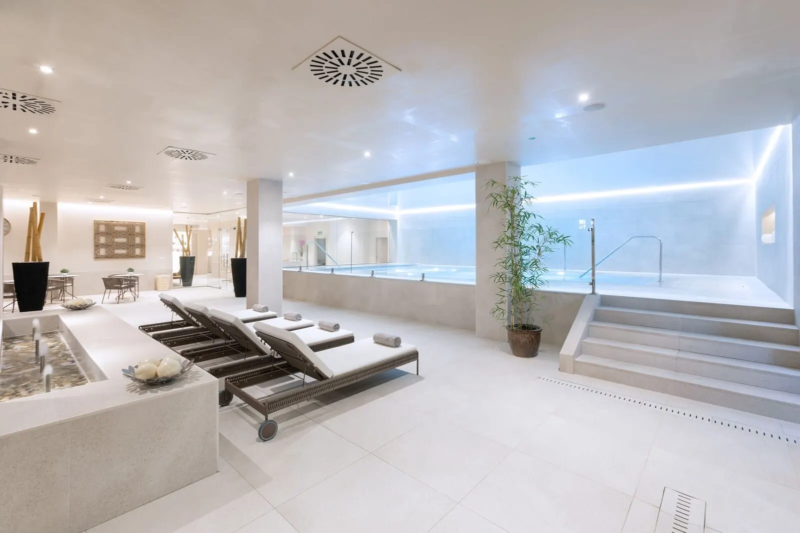 Hotel Riu Garoé: A modern spa area with a pool, lounge chairs, and a staircase leading to an upper level