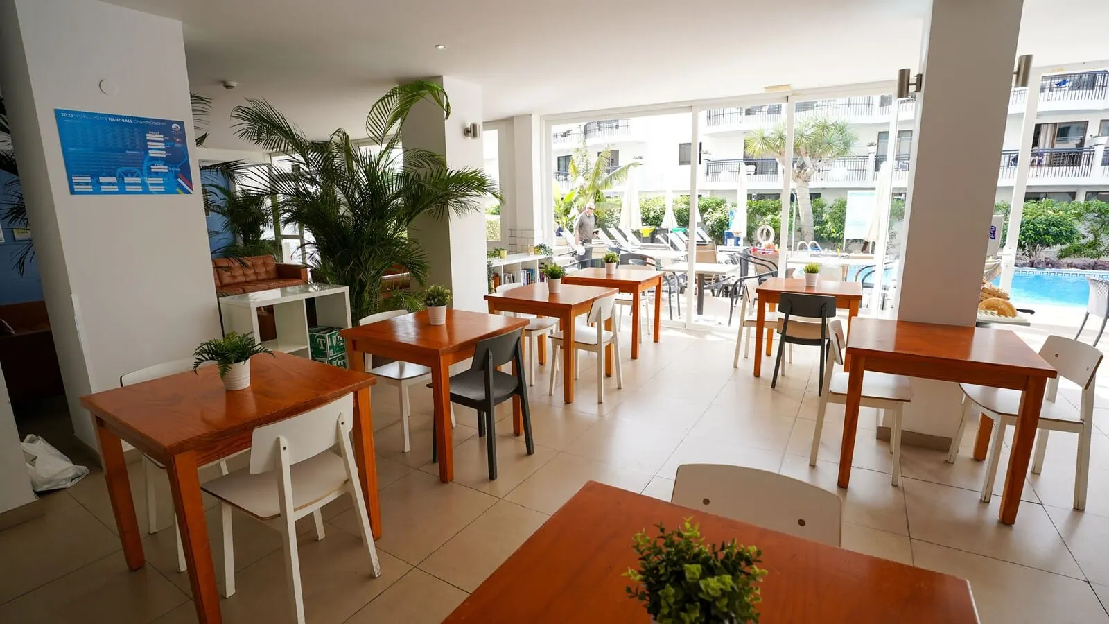 Coral California: A modern indoor dining area with wooden tables and chairs, potted plants