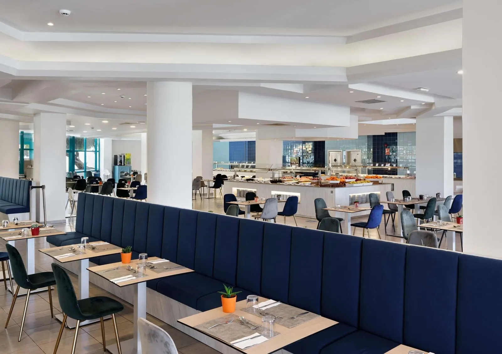 Alua Tenerife: A modern restaurant with high ceilings, a central buffet