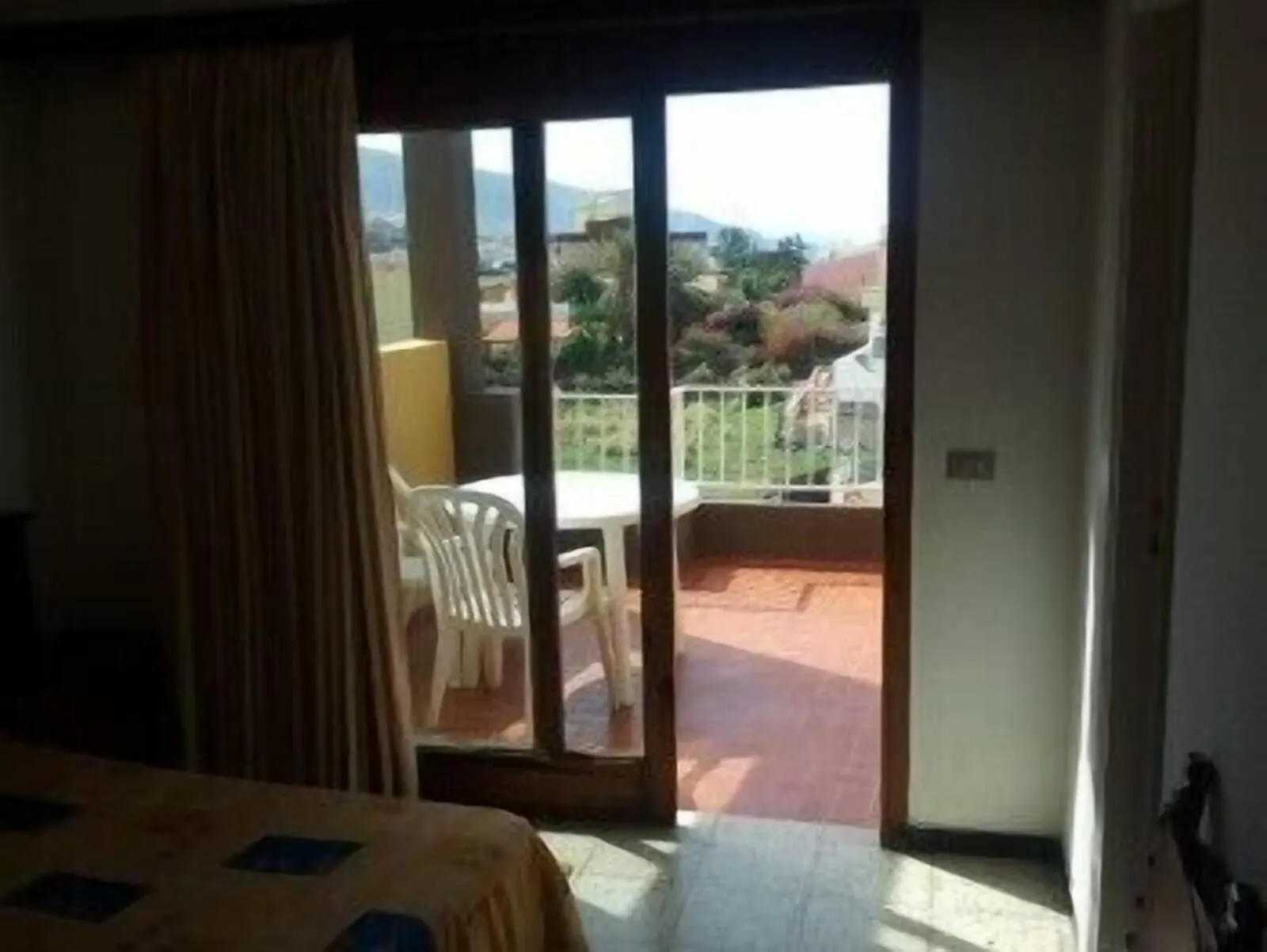 Hotel Tejuma: A hotel room with a balcony, a bed, and a view of the surrounding landscape