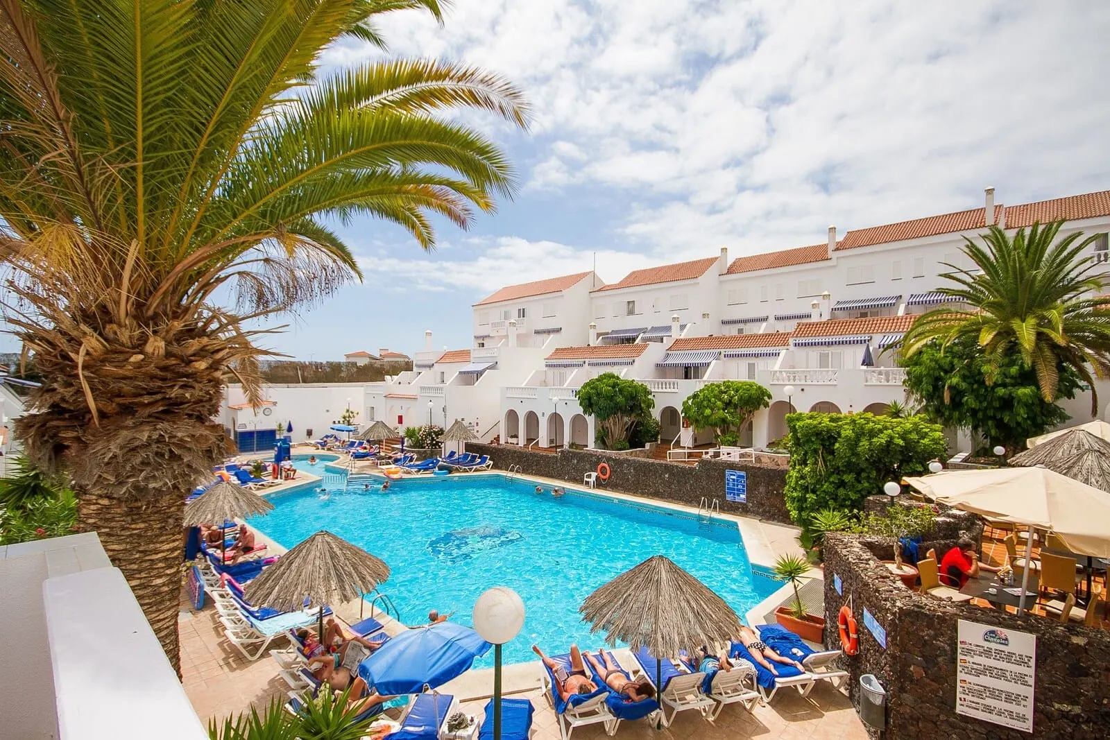 Ona Los Claveles: A pool area with lounge chairs and umbrellas