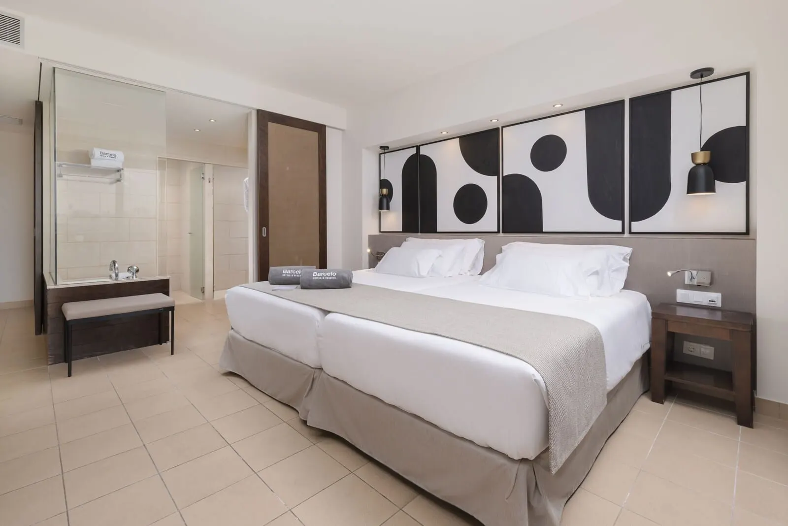 Barceló Tenerife: A double bed with a bench, a bedside table, a mirror, and abstract wall art