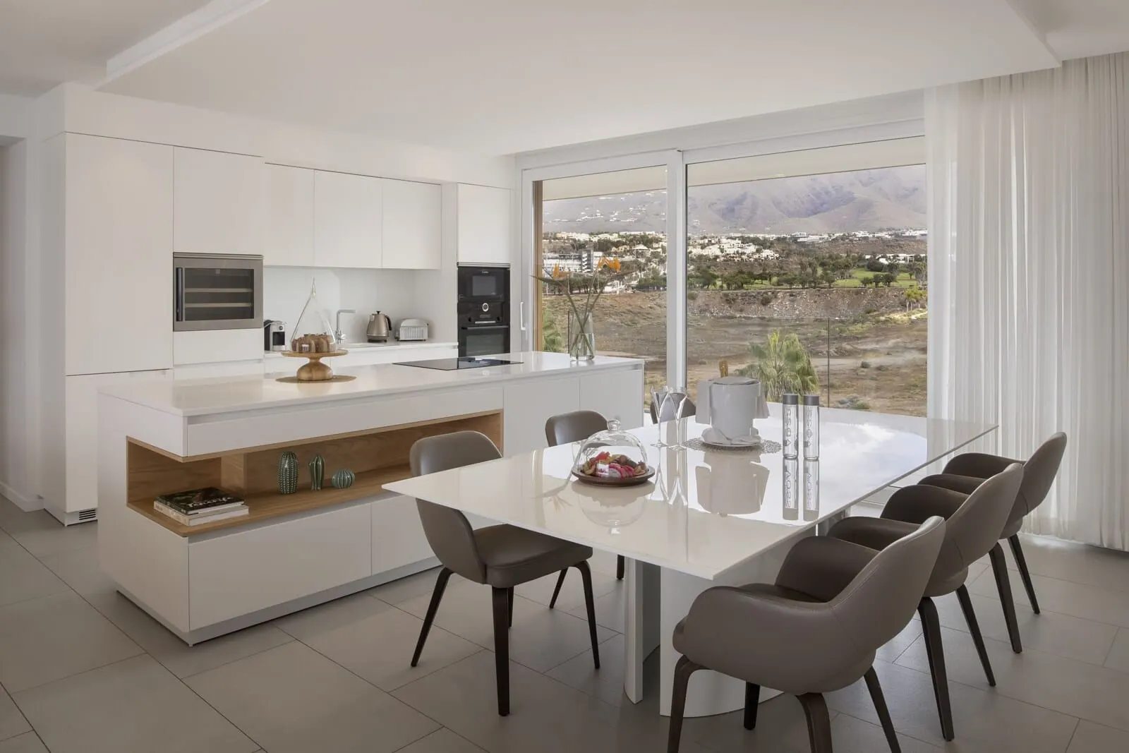 Royal Hideaway Corales Suites: A modern kitchen with white cabinetry, a central island with seating