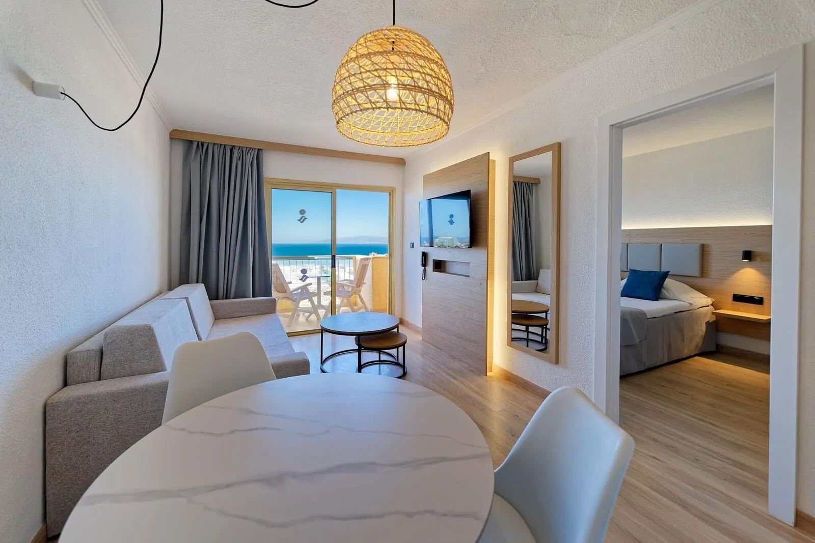 Servatur Caribe: A modern hotel room with a balcony, a dining area, and a living space