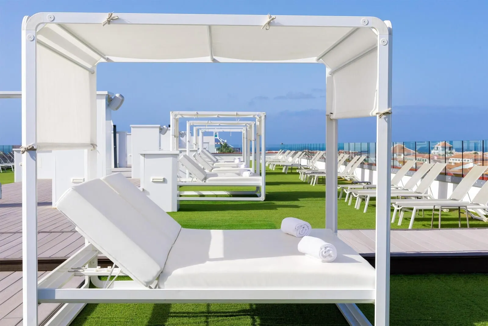 Alexandre La Siesta: A row of white sun loungers with white canopies